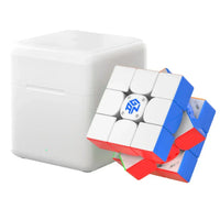 Smart speed cube with blue and red sides next to white charging dock