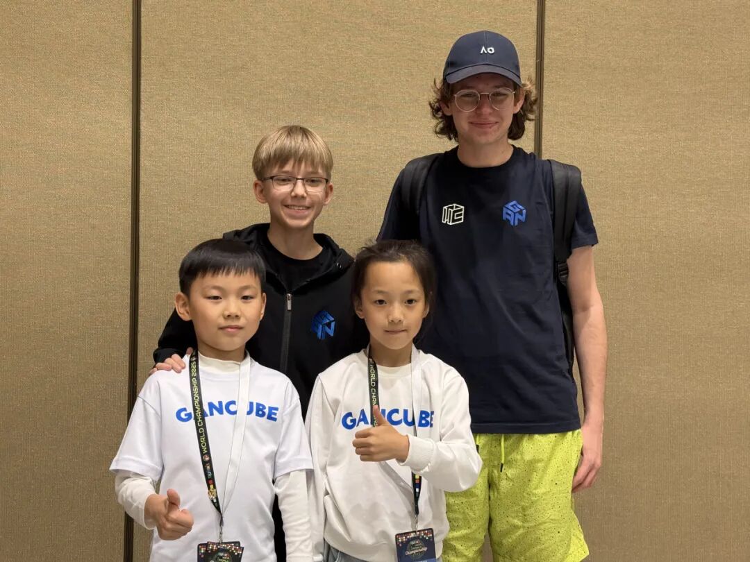 Timofei posing with Tymon, Geng Xuanyi, and Cao Qixian at a cubing event