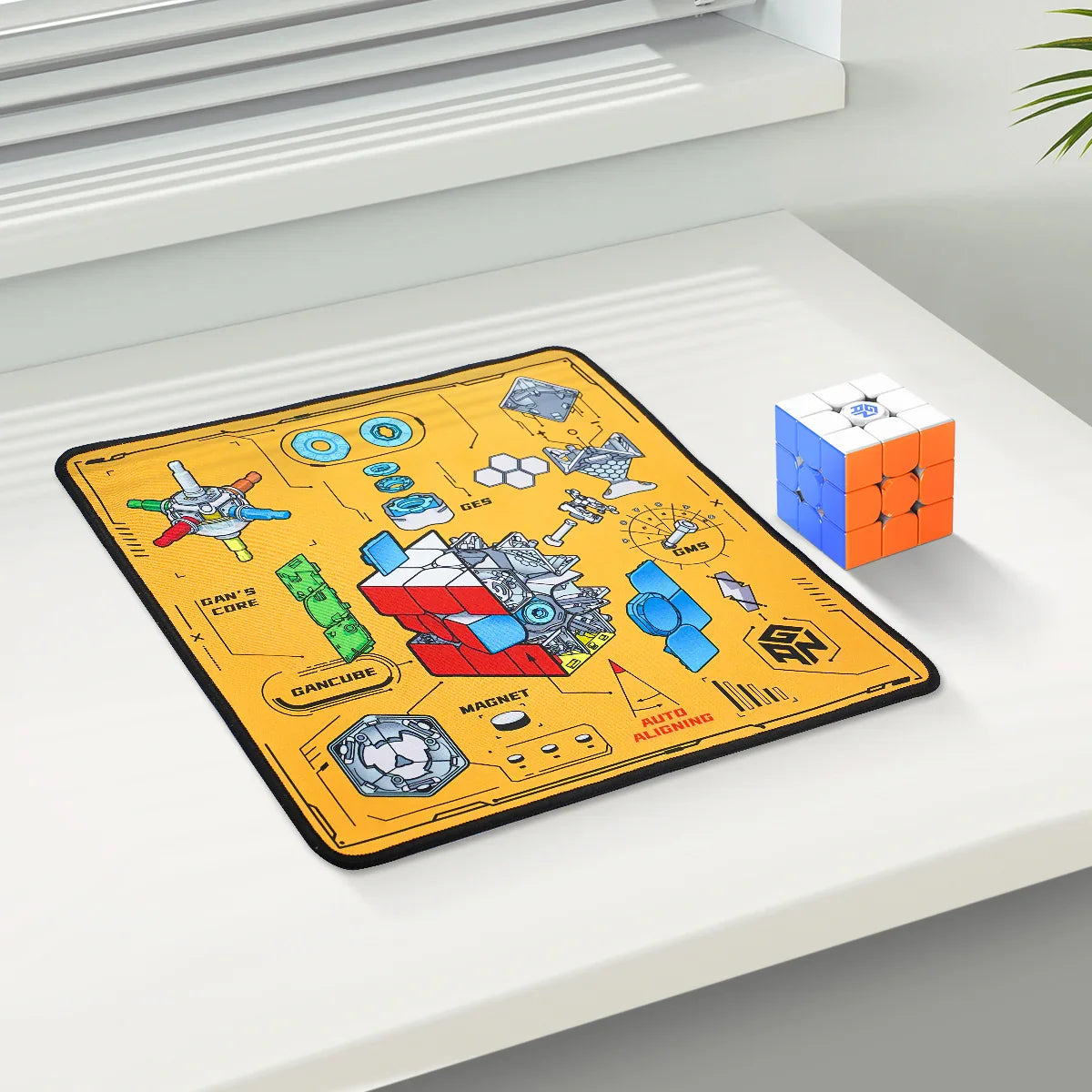 Clean white desk with colorful 3x3 speedcube and yellow Gancube puzzle mat detailing cube core and magnet system