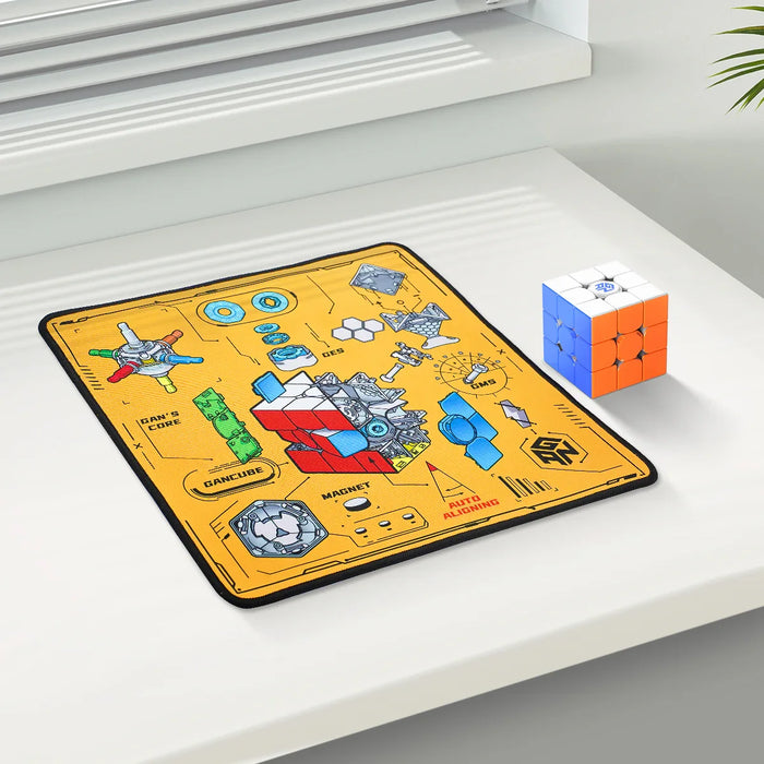 Clean white desk with colorful 3x3 speedcube and yellow Gancube puzzle mat detailing cube core and magnet system